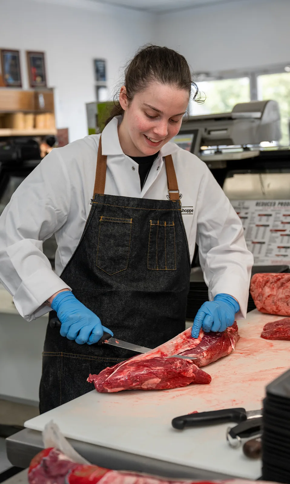 A butcher hand-trimming premium beef