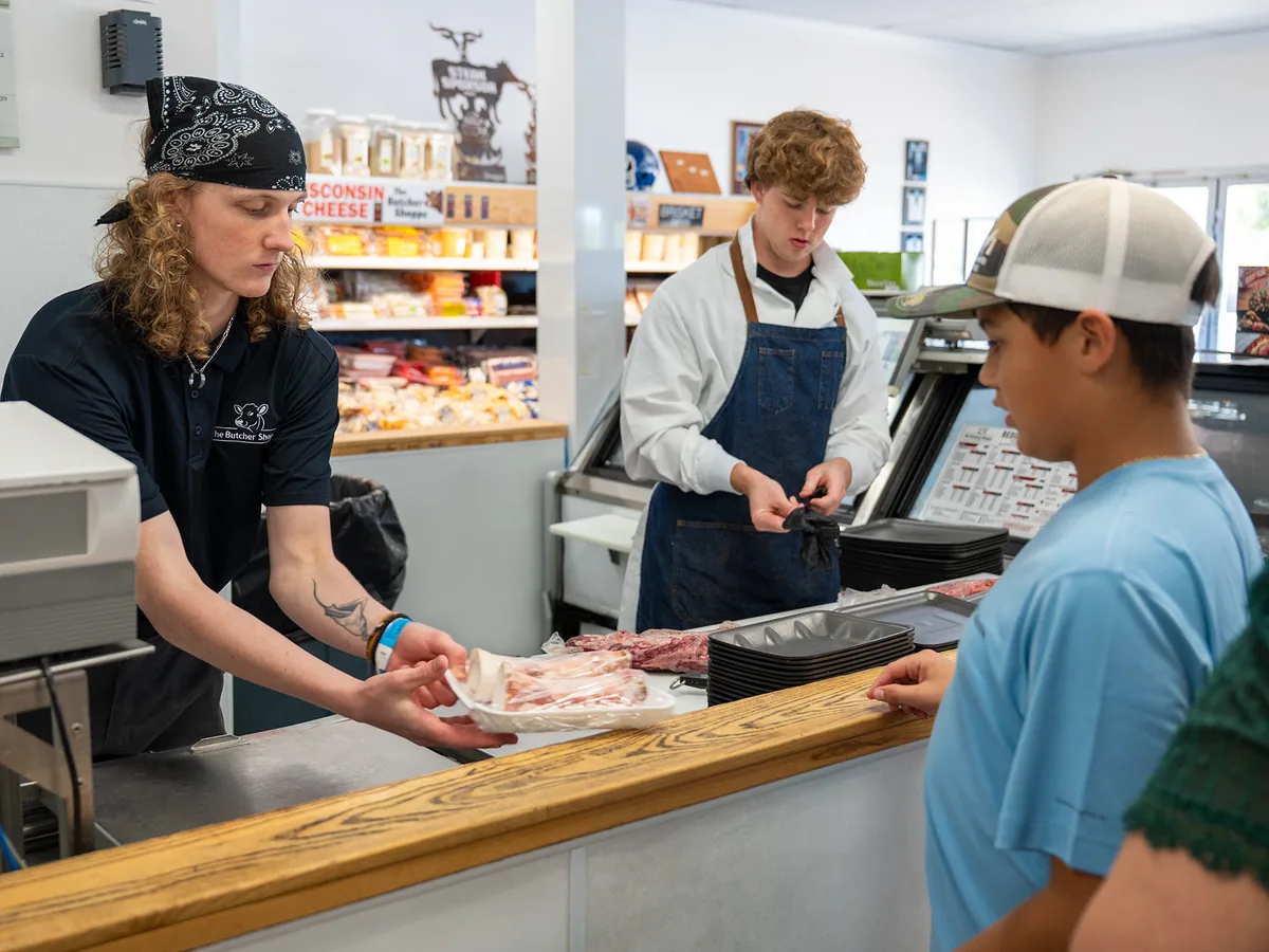A butcher serving a customer at the counter